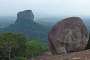 Sigiriya's rock seen from the top of Pidurangula rock. Note the hilly landscape in the hazy background. Sigiriya rock is the site of an ancient citadel built on three levels by King Kashyapa during the 5th century AD. On top of the rock are the ruins of the upper palace, there is a terrace at mid-level which includes the Lion Gate and the mirror wall with frescoes and there are some lower palaces surrounded by gardens, moats and ramparts on the ground (source Wikipedia). 