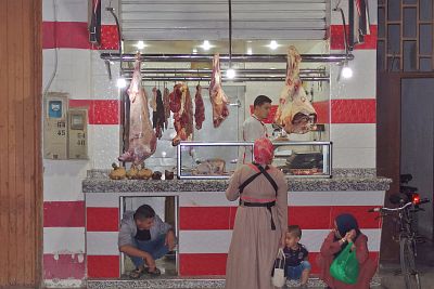 Shopping at a butcher's shop in the evening.