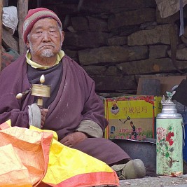Day 12: old man with prayer wheel. Note the Chinese flask next to him with its typical flowery design (and the missing top, now replaced by a plastic bag).