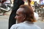 Street barber waiting for customers in Lucknow. His hair is tainted with hennah, a colour frequently used by Indian men to hide their whitening hair.