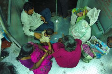 En route pour Chennai Airport: une famille voyageant dans un train de banlieue. (les portes sont toujours ouvertes, même quand le train roule.)