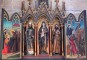 The triptych of Saint Clare in the deambulatory. Saint Clare is framed by Saint Francis on the right and by Saint Clement on the left. Saint Clement is pictured with a small dragon crouched at his right foot. This is the Graoully, a mythical dragon which has become the symbol of Metz and the Lorraine. According to legend, the Graoully was a fearsome dragon that lived in the ruins of the Roman amphitheatre in Metz and terrorised the city in the 3rd century. It was subdued with the sign of the cross by Saint Clement of Metz, the city's first bishop who led it into the river Seille to disappear for ever.