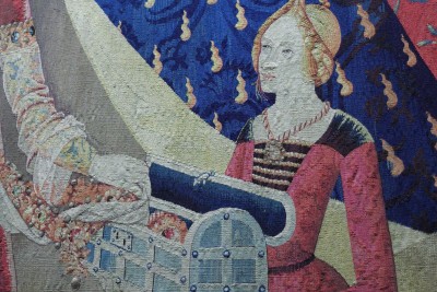Detail of the tapestry dedicated to desire: the pretty maiden holding the chest of jewels for her lady.