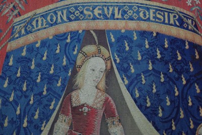 Detail of the tapestry dedicated to desire: the lady in front of the tent. Golden flames, emblems of the Holy Spirit, dot its precious blue fabric - a colour associated with the Virgin, nobility and spirituality. Translated from Beaux Arts magazine.