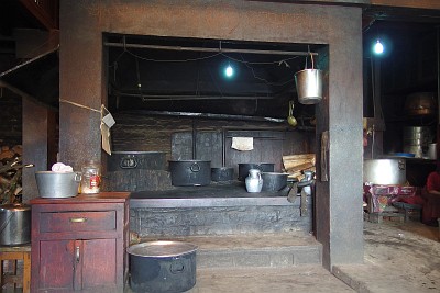 The kitchen at Thupten Choling Monastery. Note how hearth and pots are kept clean, one would nearly think they are not used. This photo was taken in the afternoon after lunch and before the evening rush. Vegetables are being washed and peeled in the rooms and corridors leading to the kitchen, the washing-up is being done in another part of the huge room not visible on the photo.