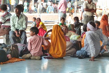 Travellers on a platform waiting for the next train