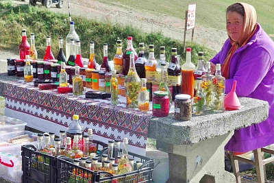 Woman selling self-made liquors and glasses of preserve and jam at Ciumârna Pass.