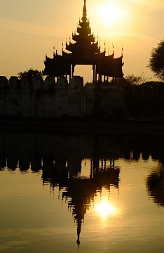 Tower of the Royal Palace at sunset and its reflection in the Palace's moat