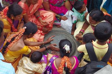 Un groupe de jeunes femmes (et leurs enfants) en train de vénérer un lingam dans le temple de Belur. Remarquez les fleurs tressées dans leur chevelure, une belle mode en Inde du Sud où les femmes de tout âge décorent leurs cheveux de guirlandes de fleurs odorantes (jasmin).
