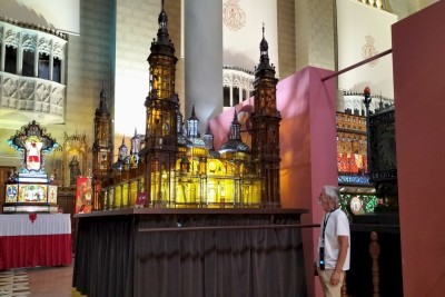 Thomas standing in front of the float representing the Basilica of the Virgin of the Pilar.