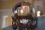 Reflection of the drawing room in a rock crystal globe set on an ornate stand made of gilt.