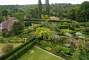 The garden with the Rondel on the right and the south cottage on the left seen from the top of the tower. The Lime Walk, designed by Harold, can be seen between the two poplars and the last neatly cut hedge. The south cottage was Harold's space where he wrote his books and retreated. It is now a private space used by the couple's grandchildren and closed to the public.